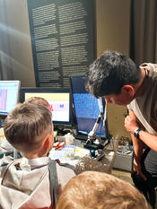 Victor Cruz engaging young minds by demonstrating the microscope setup